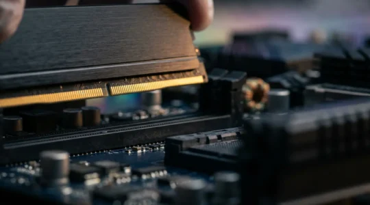 Installation minutieuse d'une barrette RAM dans un slot de carte mère moderne