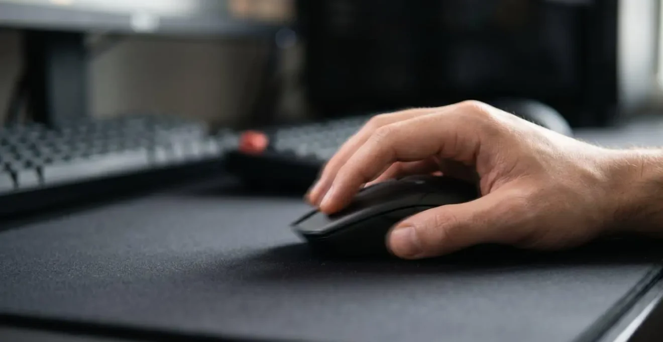 Main d'un joueur effectuant un mouvement rapide avec une souris gaming sur un tapis, capturant l'intensité du geste