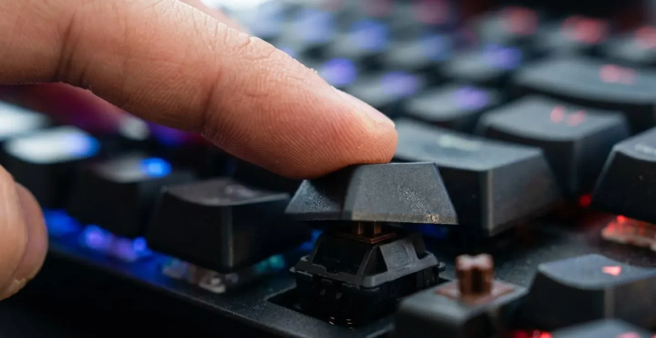 Gros plan sur les mains d'un joueur en pleine partie de StarCraft avec mouvements rapides sur clavier mécanique